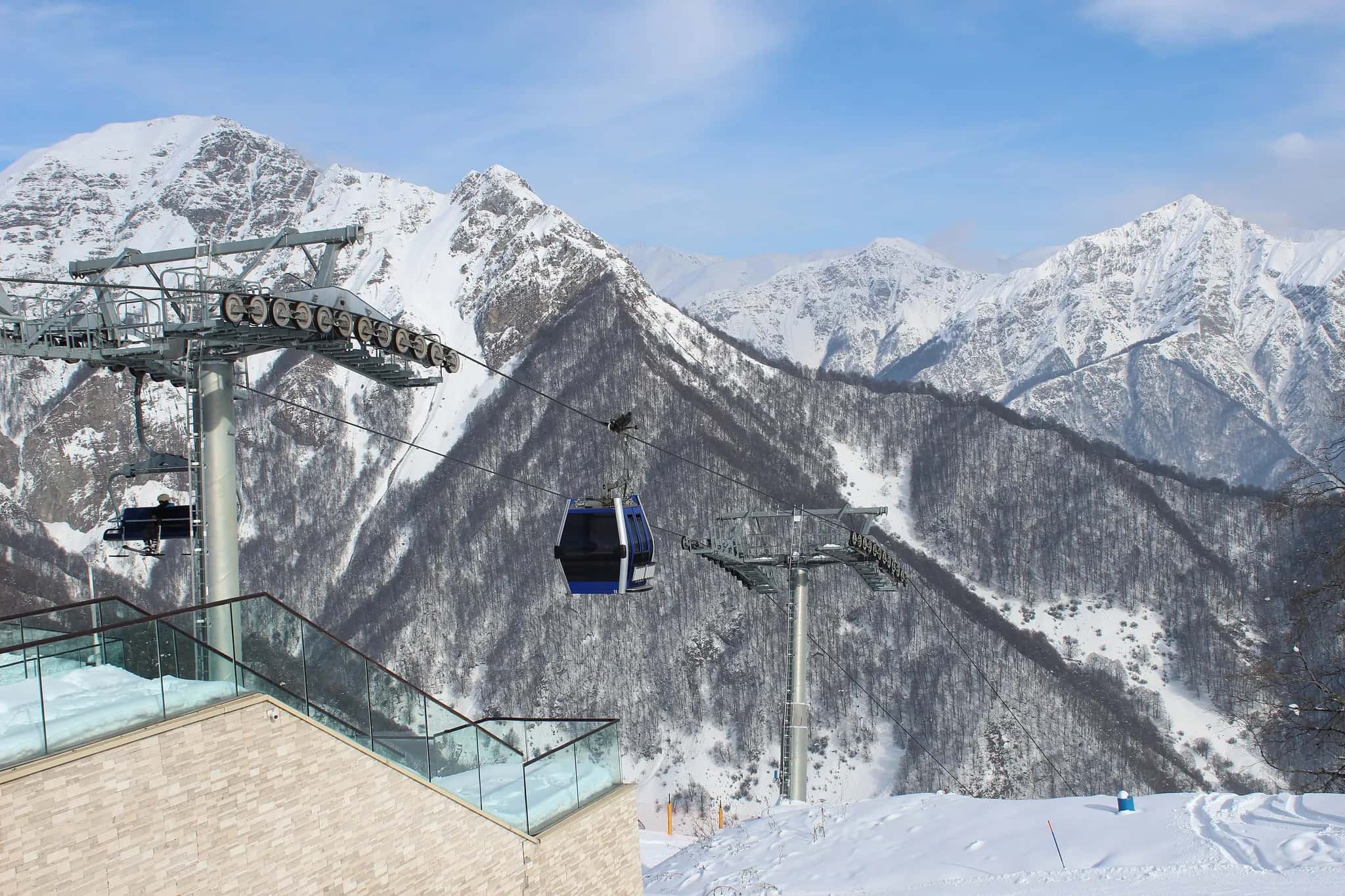 A Tufandag cable car cabin passing in front of snow-covered peaks