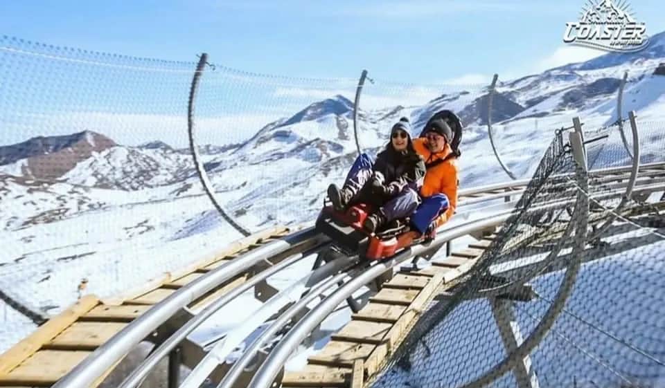 A two-seat sled on Shahdag Coaster against snowy mountains