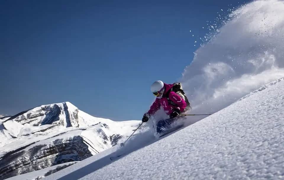 A skier carving through fresh powder at Shahdag